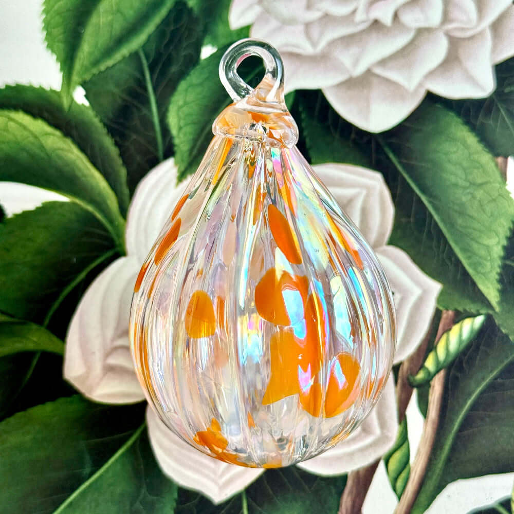 Salmonberry glass ornament from the Lacey Collection featuring a teardrop shape with vibrant orange and iridescent designs.